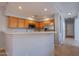 Updated kitchen with breakfast bar, wood cabinets, and stainless steel refrigerator is perfect for entertaining at 931 S Racine Ln, Gilbert, AZ 85296
