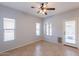Bright living room featuring tile floors, three windows, and a ceiling fan, offering a comfortable space at 931 S Racine Ln, Gilbert, AZ 85296