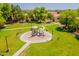 Aerial view of a community park with playground, grassy area, and walking paths at 931 S Racine Ln, Gilbert, AZ 85296
