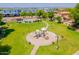 Community park featuring a playground, pool, and grassy area surrounded by trees at 931 S Racine Ln, Gilbert, AZ 85296