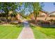 A beautifully maintained sidewalk flanked by healthy green grass, landscaping and quaint properties at 931 S Racine Ln, Gilbert, AZ 85296