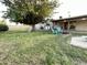 Expansive backyard with lush green grass, mature tree, and cozy seating area with fire pit at 9615 N 34Th Ave, Phoenix, AZ 85051
