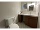 Bathroom features a white countertop with brown wood drawers and window, providing a bright and clean space at 9615 N 34Th Ave, Phoenix, AZ 85051