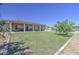 Expansive backyard featuring a lush lawn, solar panels, covered patio and outdoor seating areas at 9759 E Brown Rd, Mesa, AZ 85207