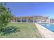 Well maintained backyard with a large sparkling pool, green grass and covered patio at 9759 E Brown Rd, Mesa, AZ 85207