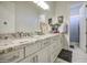 Bright bathroom featuring marble floors, double sinks, and white cabinets at 9759 E Brown Rd, Mesa, AZ 85207