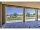 Spacious covered patio with stone flooring looks out to a grass back yard featuring green trees at 9759 E Brown Rd, Mesa, AZ 85207