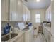 Well-lit laundry room featuring modern appliances, ample storage cabinets and gray toned wood look flooring at 9759 E Brown Rd, Mesa, AZ 85207