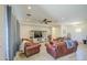 Spacious living room featuring hardwood floors, ceiling fan, and plush leather furniture at 9759 E Brown Rd, Mesa, AZ 85207