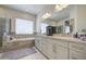 The main bathroom features a tub, double vanity and a large window that offers natural light and air at 9759 E Brown Rd, Mesa, AZ 85207