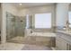This bathroom features a glass shower, tub and a window that offers natural light and air at 9759 E Brown Rd, Mesa, AZ 85207