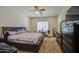 Comfortable carpeted main bedroom features a ceiling fan, window, and dresser, offering a relaxing retreat at 9759 E Brown Rd, Mesa, AZ 85207