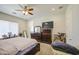 The main bedroom features a ceiling fan, carpet, a TV and a dresser that offers convenient bedroom storage at 9759 E Brown Rd, Mesa, AZ 85207