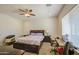 Bright main bedroom with ceiling fan, ample natural light, and a cozy workspace for convenience and relaxation at 9759 E Brown Rd, Mesa, AZ 85207