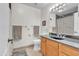 This bathroom has a wood vanity, a dark countertop, and neutral tile floors at 1044 E Irvine Rd, Phoenix, AZ 85086