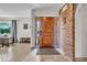 Inviting entryway featuring a solid wood door, tiled flooring, and a charming brick wall with decorative accents at 1044 E Irvine Rd, Phoenix, AZ 85086