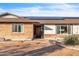 Front exterior showcases a brick and stucco finish, a rustic wooden door, and modern solar panels on the roof at 1044 E Irvine Rd, Phoenix, AZ 85086