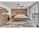 This primary bedroom features wood-look tile, brick accent wall, ceiling fan and slider to the backyard at 1044 E Irvine Rd, Phoenix, AZ 85086