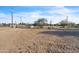Wide shot of the property entrance with gravel driveway, desert landscaping, and a basketball hoop in the distance at 1044 E Irvine Rd, Phoenix, AZ 85086