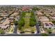 High-angle aerial view of a well-planned community with manicured park in the foreground at 10618 E Kinetic Dr, Mesa, AZ 85212