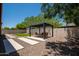Backyard featuring a pergola with seating, artificial grass and gravel, creating a serene outdoor space at 10618 E Kinetic Dr, Mesa, AZ 85212