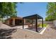 A beautiful backyard featuring a pergola with seating, and a patch of artificial grass at 10618 E Kinetic Dr, Mesa, AZ 85212