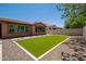 Low maintenance backyard with a patch of artificial grass, bordered by gravel and concrete pavers at 10618 E Kinetic Dr, Mesa, AZ 85212