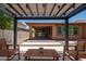 Shaded pergola with an outdoor seating area overlooking manicured gravel and artificial turf at 10618 E Kinetic Dr, Mesa, AZ 85212