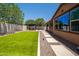 Low maintenance backyard with synthetic grass and a paved walkway to a pergola at 10618 E Kinetic Dr, Mesa, AZ 85212