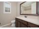 Bathroom features a vanity with a large mirror, single sink, and a nearby toilet at 10618 E Kinetic Dr, Mesa, AZ 85212
