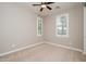 A neutral-toned bedroom featuring plush carpeting, a ceiling fan and plantation shutters at 10618 E Kinetic Dr, Mesa, AZ 85212