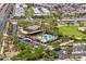 Aerial view of a community pool with lounge chairs, palm trees, parking and a recreational building in the neighborhood at 10618 E Kinetic Dr, Mesa, AZ 85212