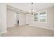 Spacious, bright dining room with neutral walls, tile floors, and modern lighting fixtures at 10618 E Kinetic Dr, Mesa, AZ 85212