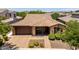 Aerial view of a charming single-story brick home with a tiled roof, manicured landscaping, and a two-car garage at 10618 E Kinetic Dr, Mesa, AZ 85212