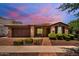 Charming single-story brick home with a tiled roof, manicured landscaping, and a two-car garage at 10618 E Kinetic Dr, Mesa, AZ 85212
