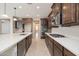 Modern kitchen featuring dark wood cabinets, stainless steel appliances, and a large island at 10618 E Kinetic Dr, Mesa, AZ 85212