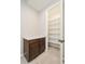 Hallway with a granite countertop and cabinetry leads into a brightly lit walk-in pantry at 10618 E Kinetic Dr, Mesa, AZ 85212