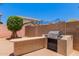 Outdoor grilling area with built in counter and barbecue, complemented by desert landscaping and blue sky at 10910 E Sebring Ave, Mesa, AZ 85212