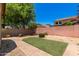 Landscaped backyard featuring artificial turf, desert landscaping and brick-lined pathways at 10910 E Sebring Ave, Mesa, AZ 85212