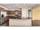 A modern kitchen island provides extra space and contrasts with the dark cabinets and stainless-steel appliances at 10910 E Sebring Ave, Mesa, AZ 85212