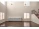 Bright living room with modern chandelier, large windows, and stairs with ornate iron railing at 10910 E Sebring Ave, Mesa, AZ 85212