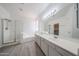Bright bathroom featuring dual sinks, a walk-in shower, and a separate soaking tub at 11548 W Cottonwood Ln, Avondale, AZ 85392