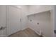 Functional laundry room with clean white walls, shelf, and access door at 11548 W Cottonwood Ln, Avondale, AZ 85392