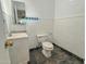 Cozy half bathroom with white vanity and a tiled accent wall at 1226 W Purdue Ave, Phoenix, AZ 85021