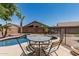 Outdoor dining area with a pool view, set for relaxed entertaining in a desert landscape at 12325 W Berridge Ln, Litchfield Park, AZ 85340