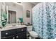 Well-maintained bathroom with a navy vanity, floral shower curtain, and decorative accents at 12325 W Berridge Ln, Litchfield Park, AZ 85340