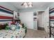 Bright bedroom featuring a ceiling fan, closet with sliding doors, and colorful striped walls at 12325 W Berridge Ln, Litchfield Park, AZ 85340