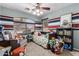 Charming bedroom featuring striped accent walls, a ceiling fan, and playful decor with toys and books at 12325 W Berridge Ln, Litchfield Park, AZ 85340