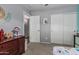 Neutral bedroom with a dresser, closet with sliding doors, and an adjacent hallway at 12325 W Berridge Ln, Litchfield Park, AZ 85340