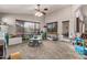 A large living room features carpet, a ceiling fan and lots of natural light at 12325 W Berridge Ln, Litchfield Park, AZ 85340